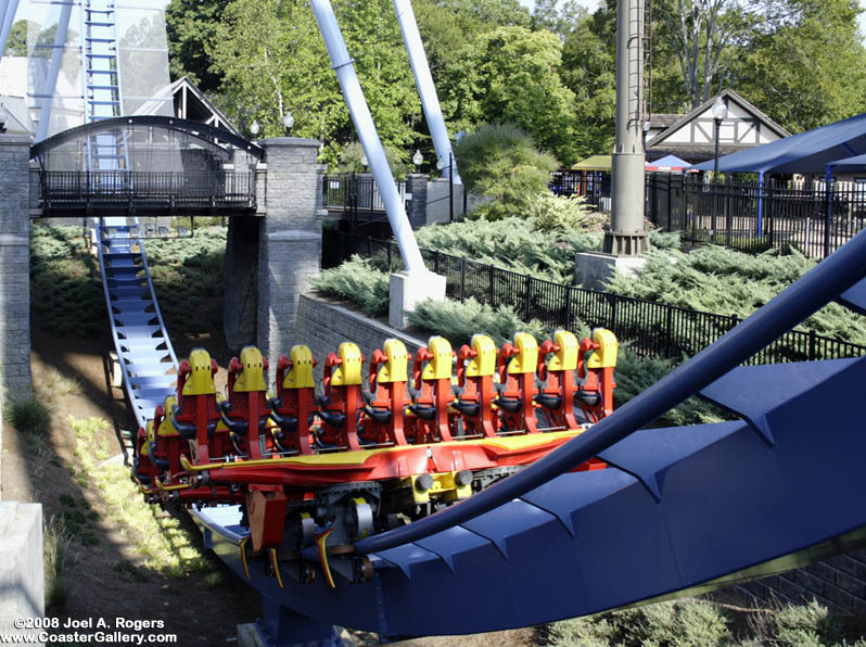 Get ready to duck! A roller coaster train going under a bridge.