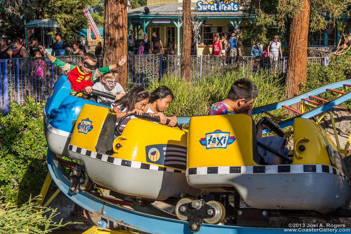 Kids in costume riding a roller coaster