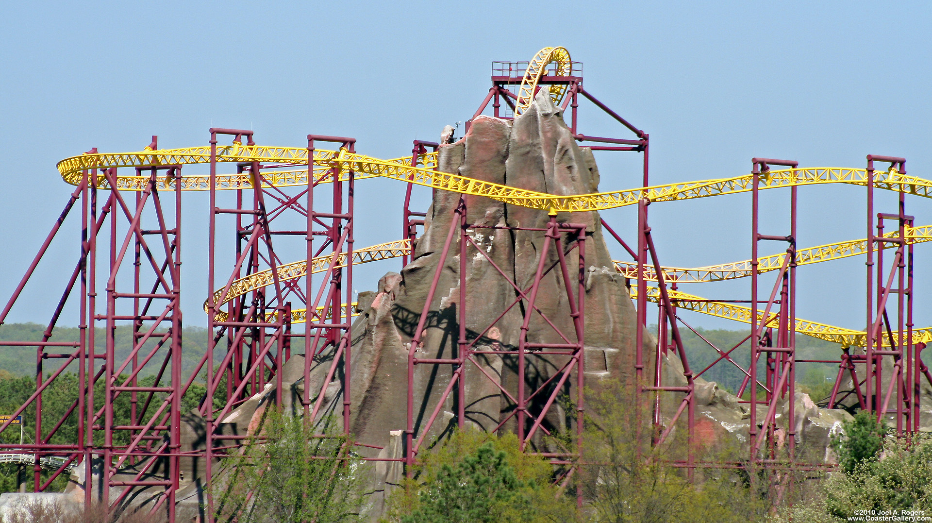 A roller coaster surrounding a mountain. It has three heartline rolls.