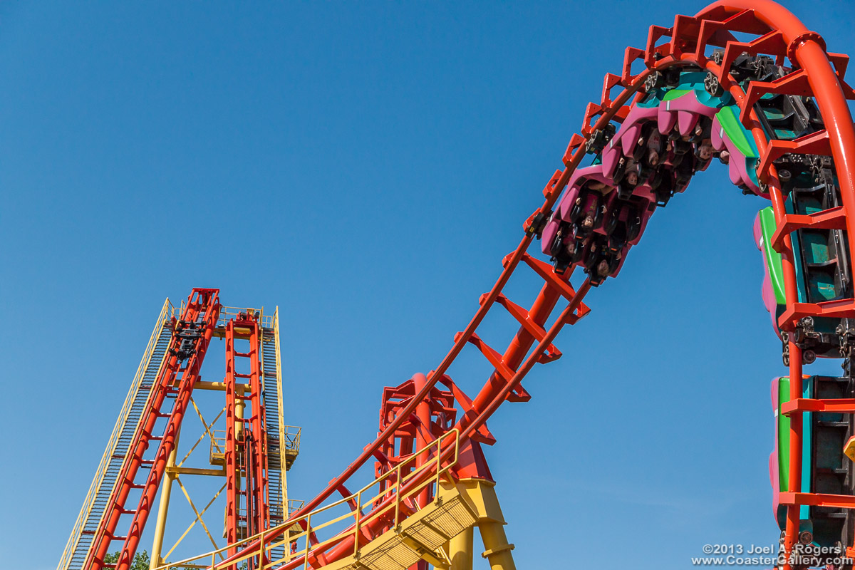 Bright colors of paint used on a roller coaster train, track, and supports.