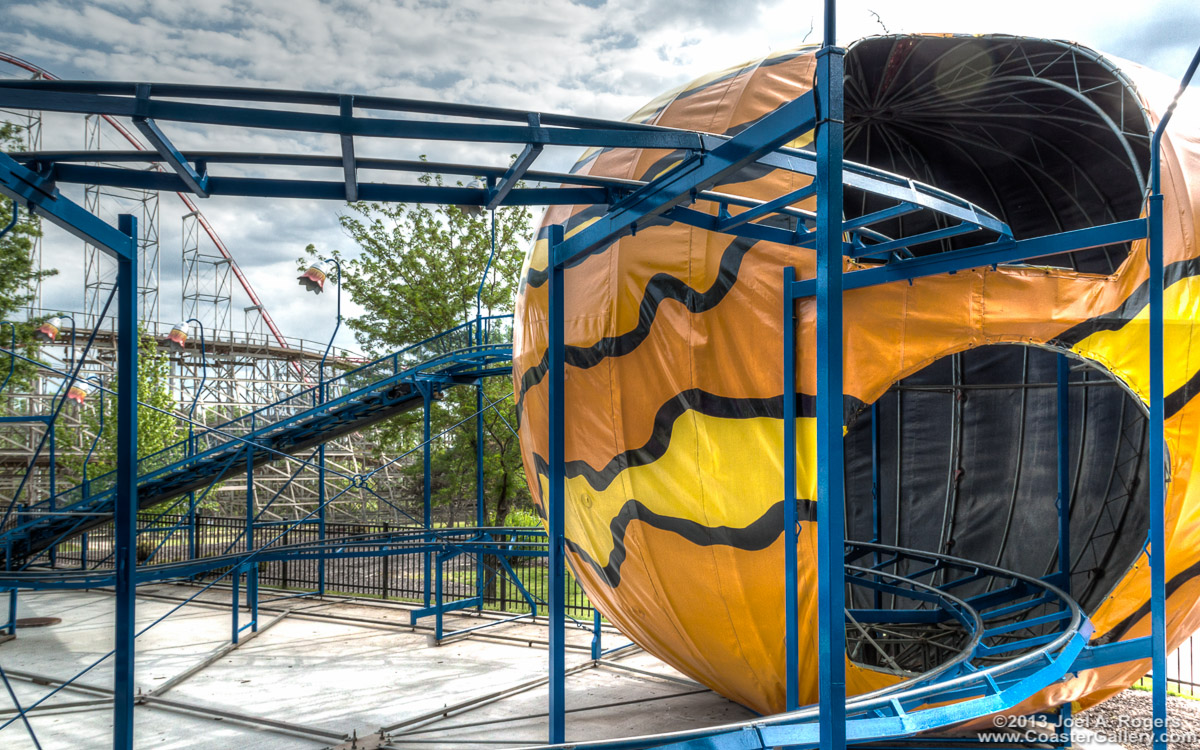 Kiddie coaster going through a big planet or Great Pumpkin.