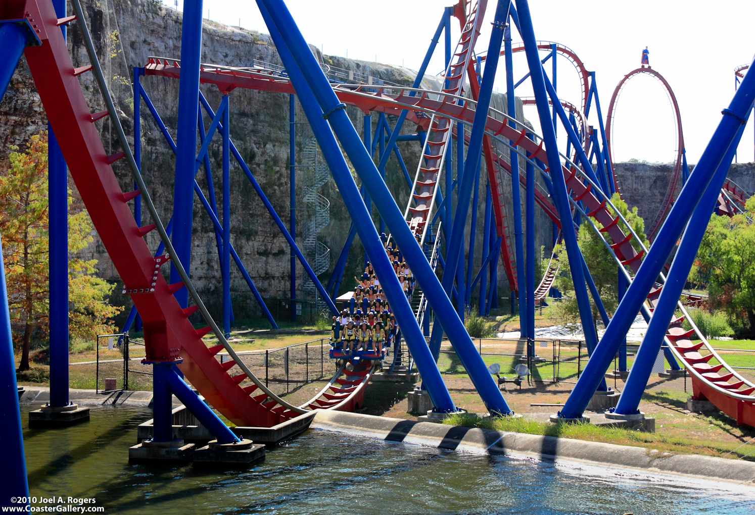 A roller coaster going through the water.