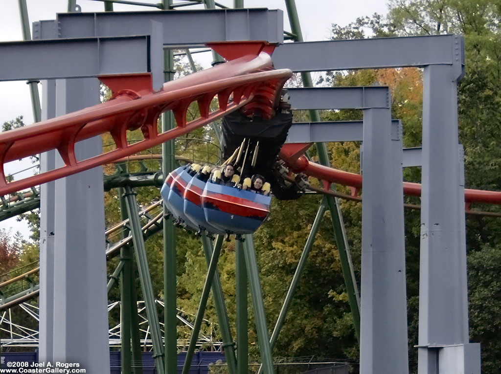 Roller coaster train swinging below its track.