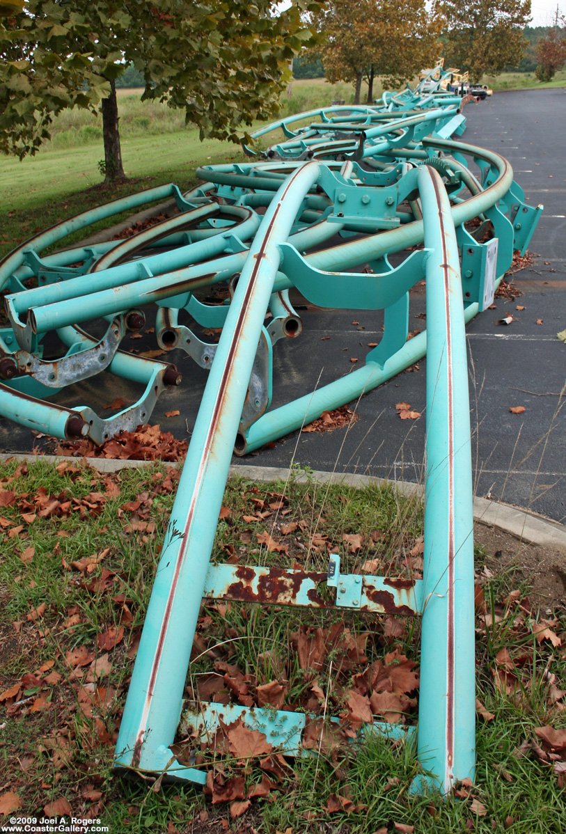 Pieces of a roller coaster sitting in parking lot