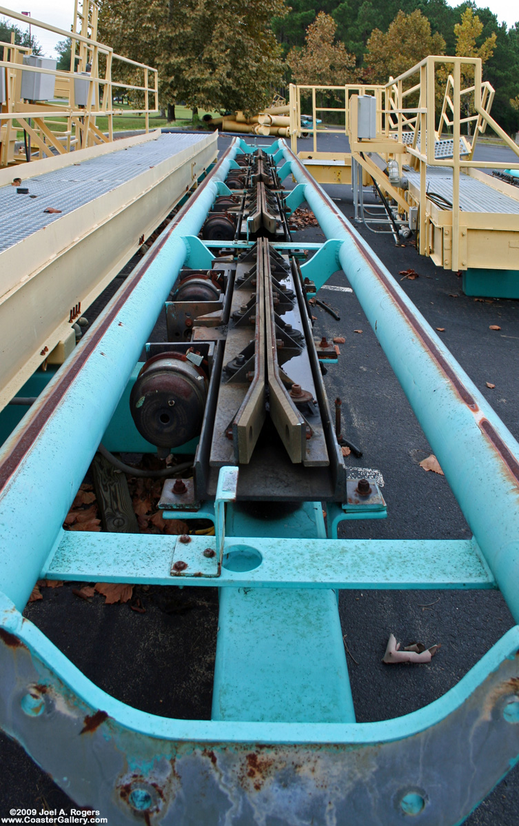 Looking down a set of brakes sitting between roller coaster rails