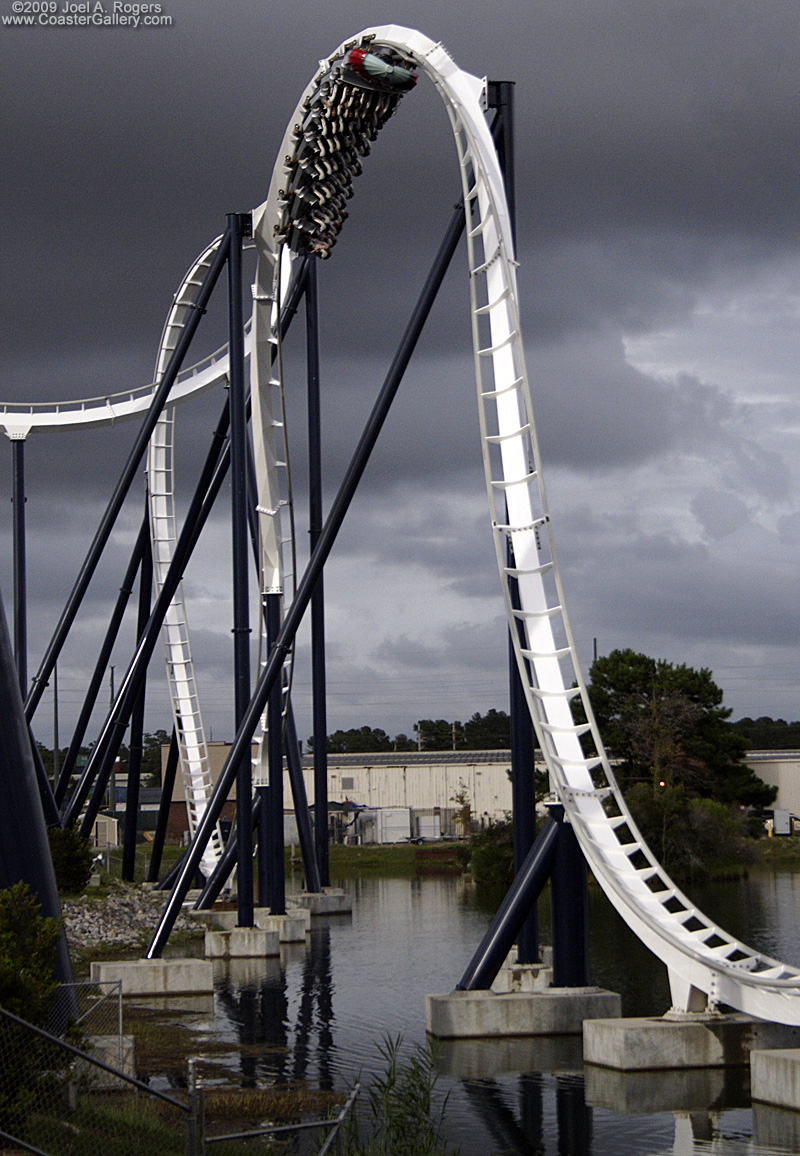 A roller coaster looping over the water