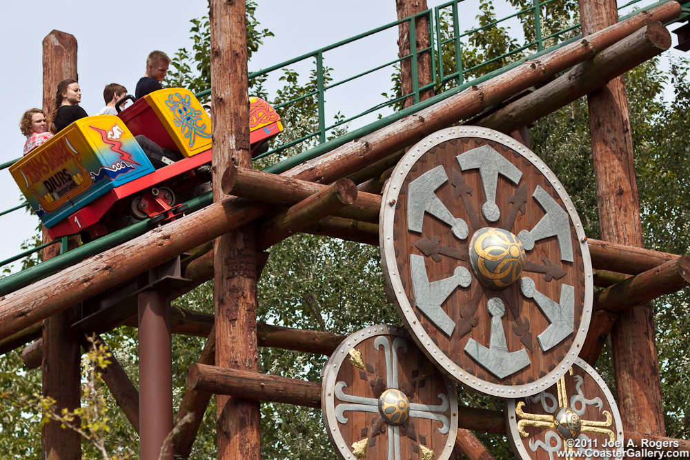 Wood logs and shields decorating a roller coaster.