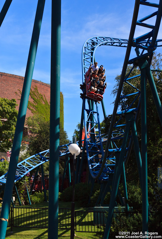 A red roller coaster car going down a blue track