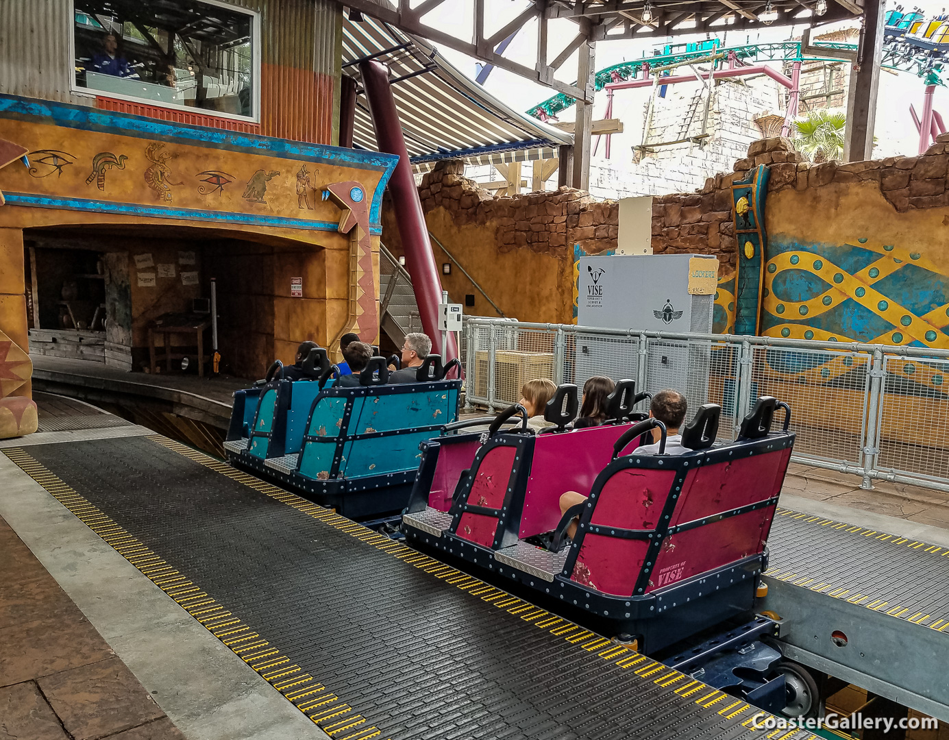 Moving walkway next to a roller coaster. Cobra's Curse is surrounded by Egyptian ruins.