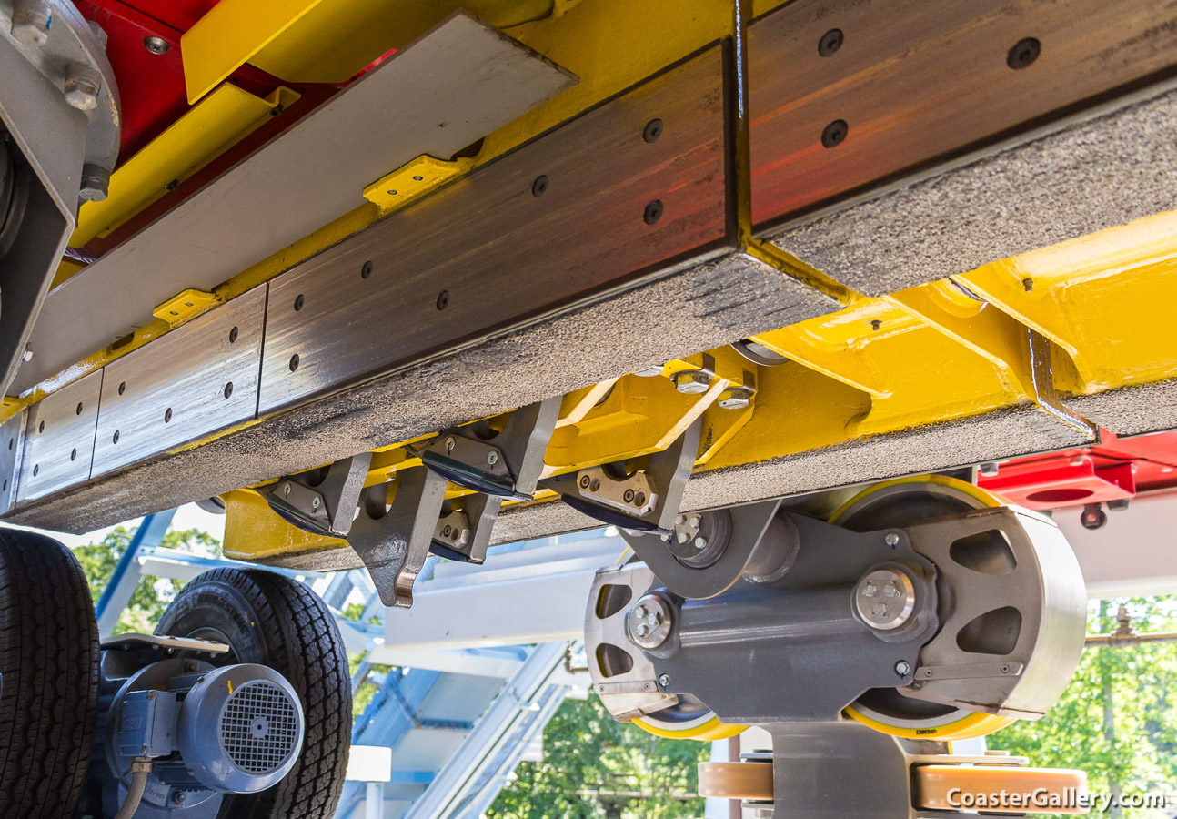 This is a view underneath a roller coaster train. It shows brake fins, anti-rollback dogs, and many wheels