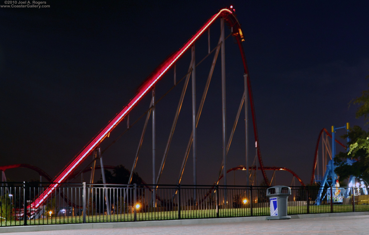 Red lights on a roller coaster at night.