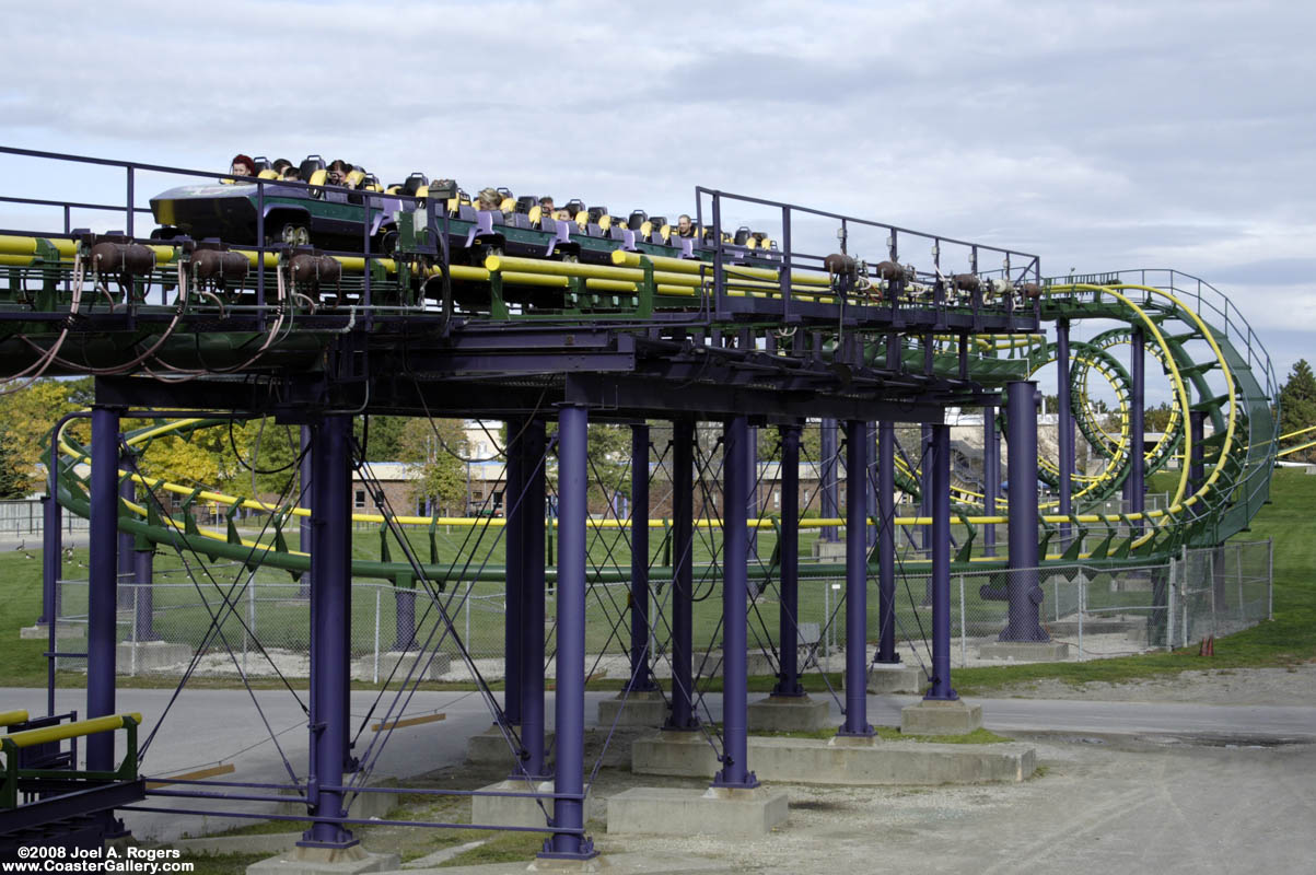 Green and yellow track. Purple supports. Looping roller coaster.