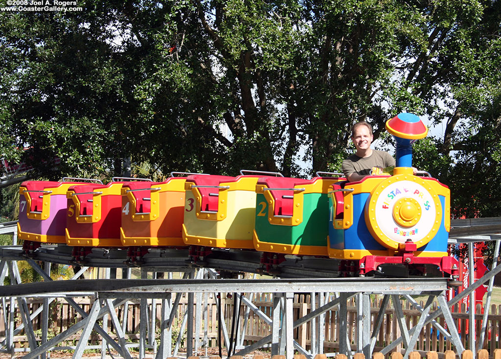 Jeffry Rogers riding a tiny roller coaster