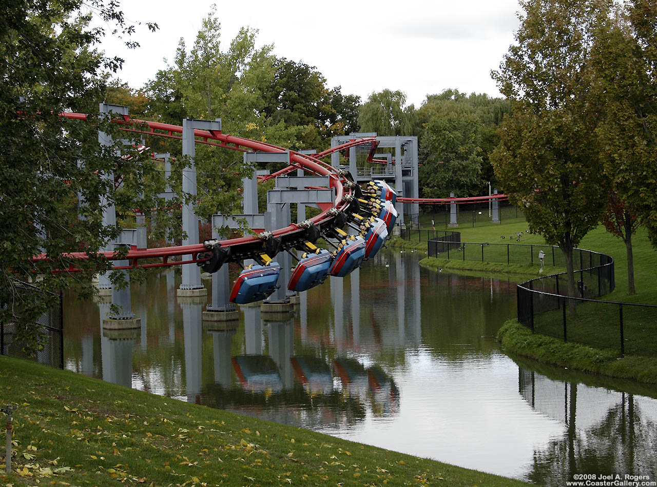 Suspended roller coaster train reflected in the water