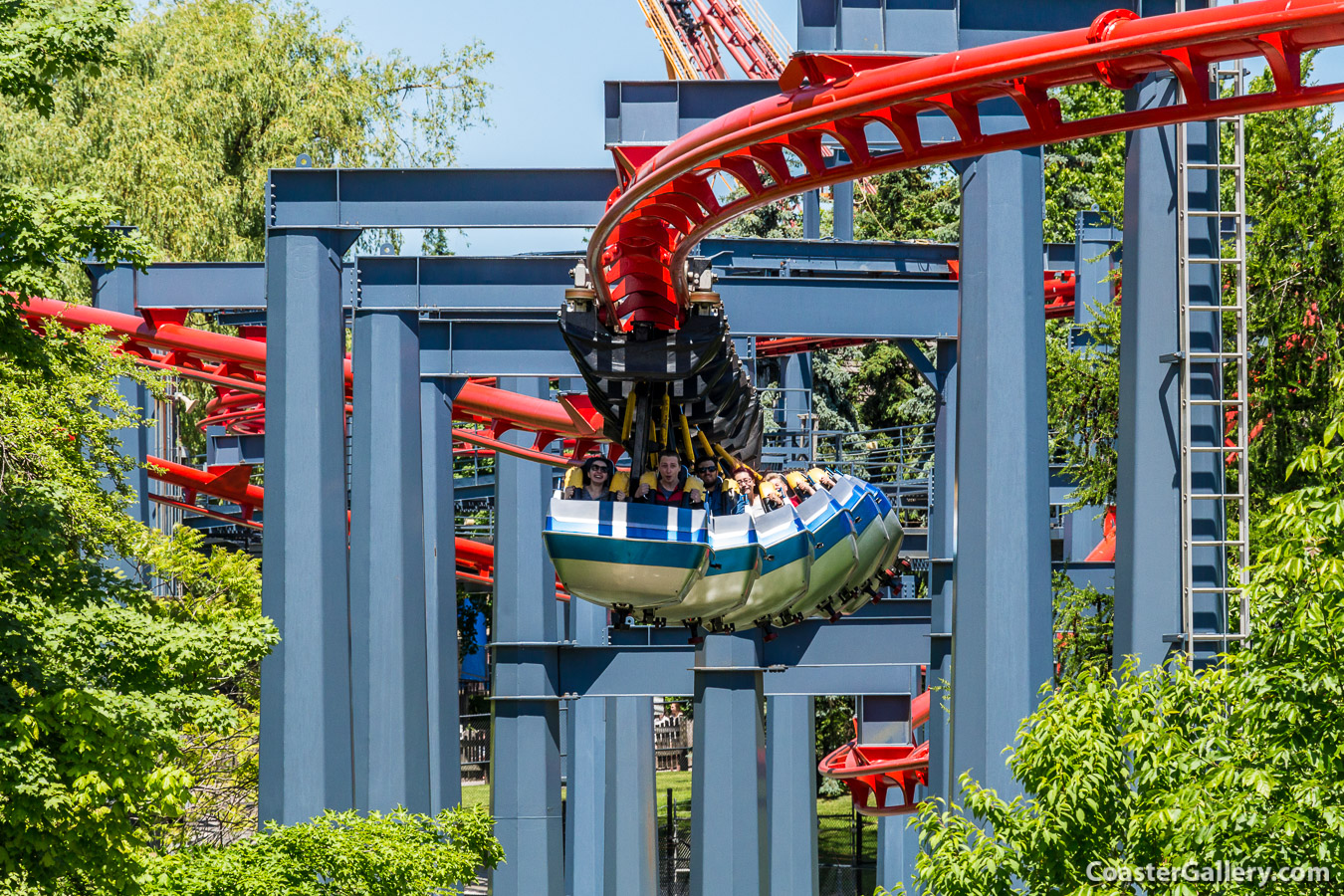 Suspended oller coaster train swinging below its track.